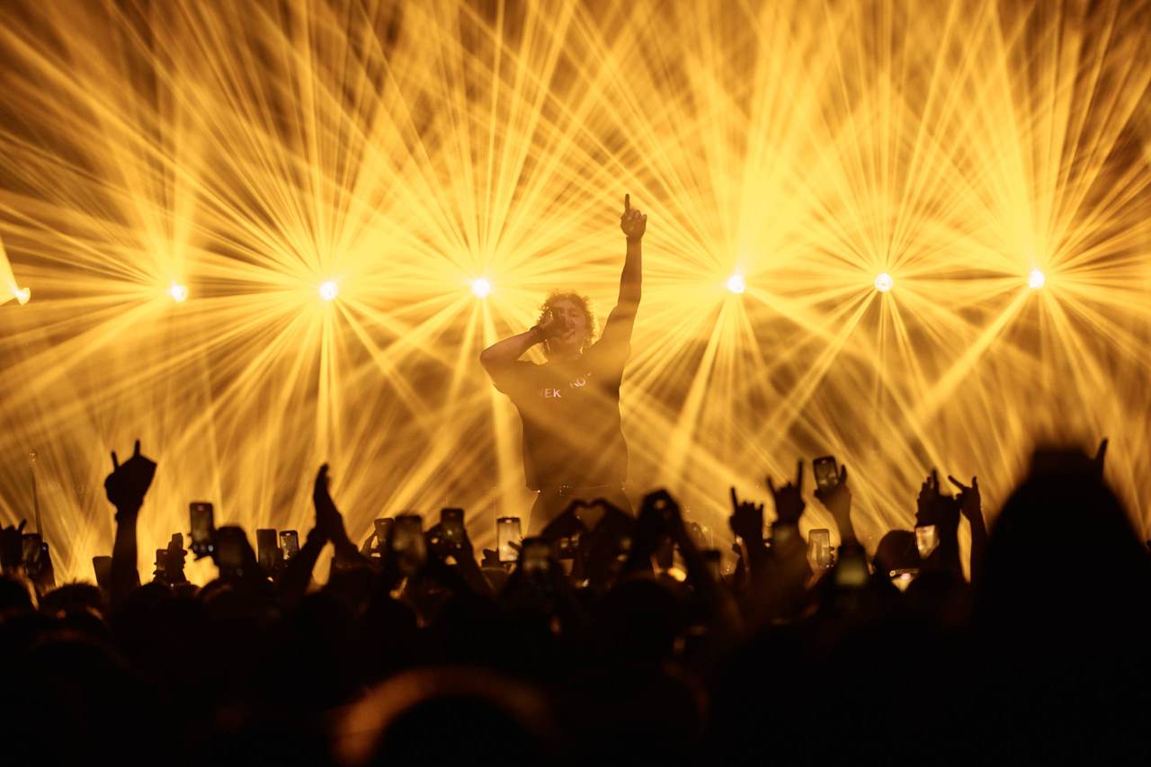 A singer in radiating golden spotlights