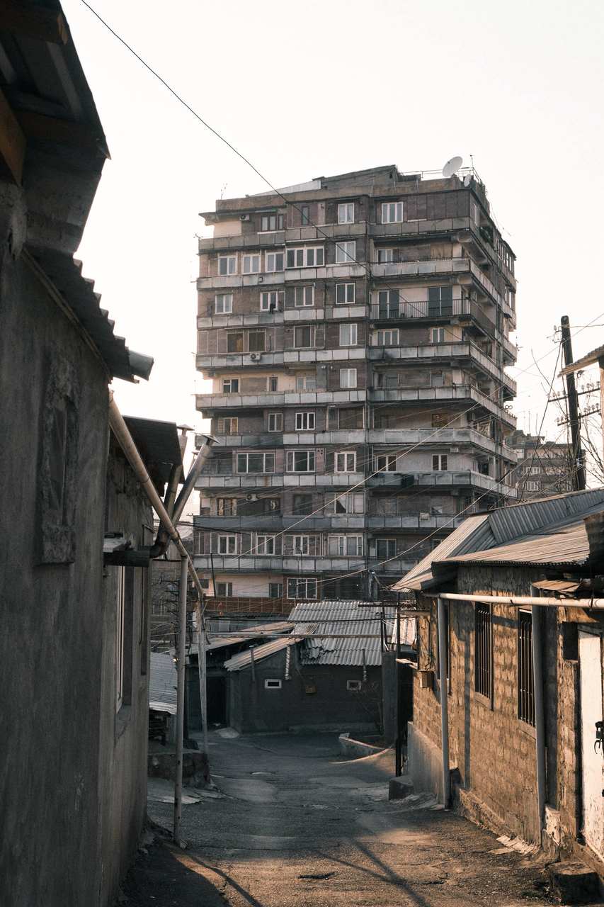 A pedestrian between concrete apartment blocks