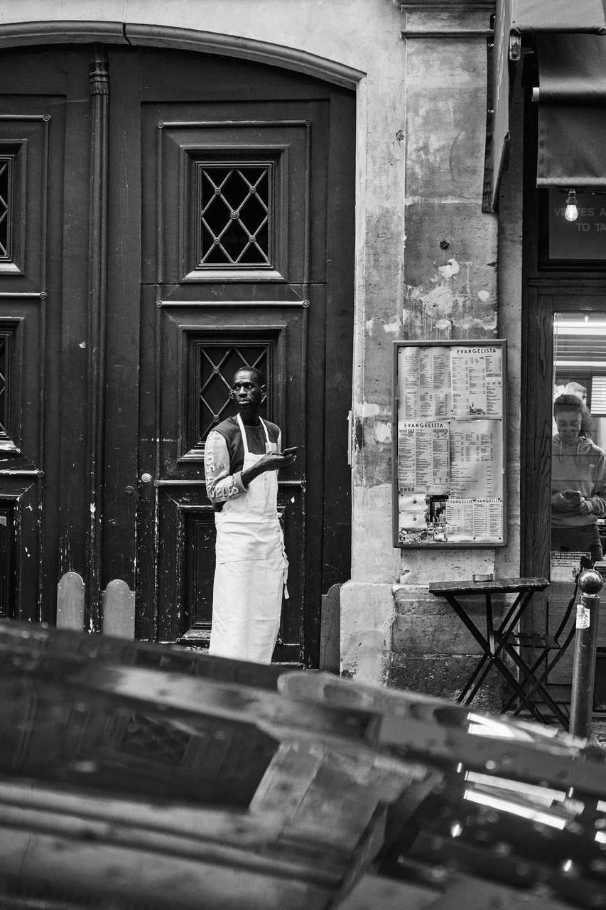 Black and white woman in a long coat in an old courtyard