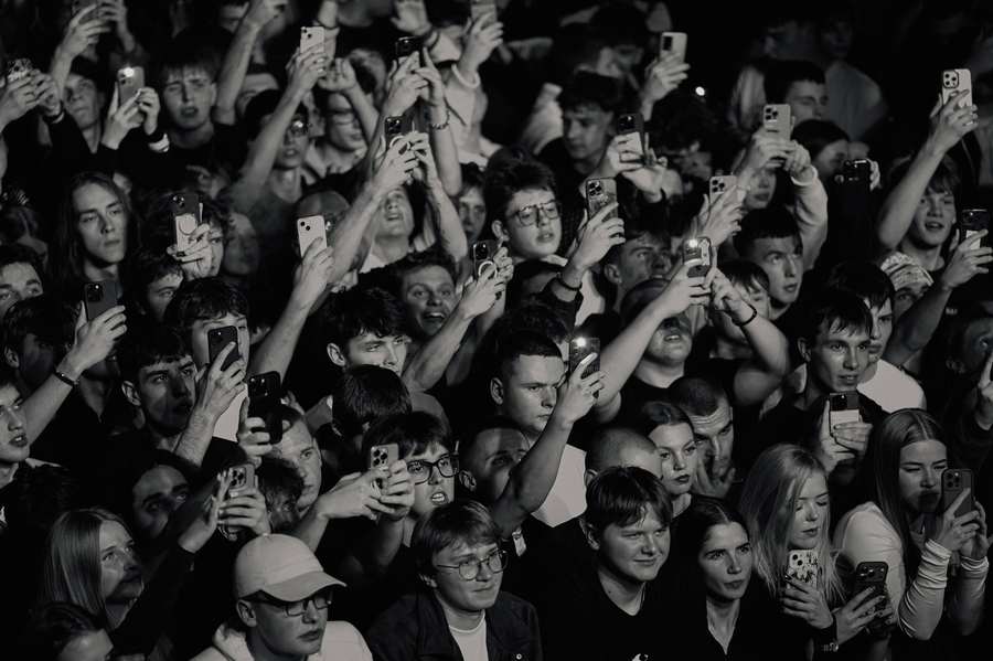 Black and white crowd shot from above with raised hands