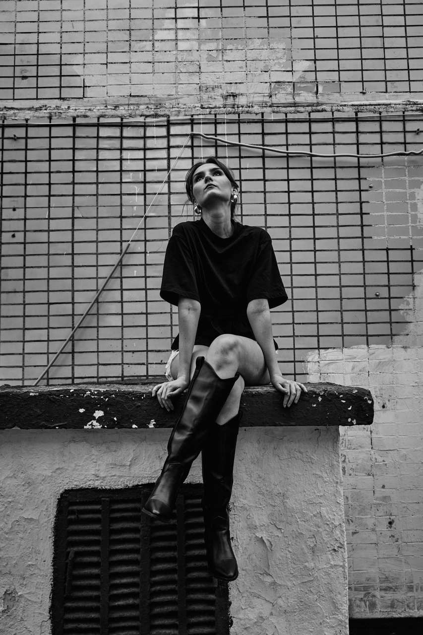 Black and white seated portrait on a concrete ledge